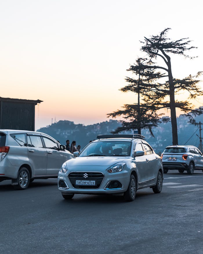 A serene evening cityscape featuring cars and people under a twilight sky.